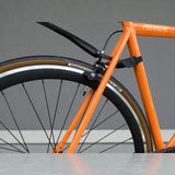 Mud guard installed on orange single-speed commuter bike