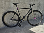 TrackloX Midnight Mirage TLX20MM – a black single-speed fixie bike with a chrome fork, purple hubs, and Arisun tires. Perfect for urban riding, bikepacking, and tracklocross