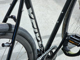 Close-up of TrackloX Midnight Mirage TLX20MM frame, drivetrain, and pedal straps. Matte black finish with bottle cage mounts, Arisun tires, and a secure pedal system for urban riding, bikepacking, and tracklocros