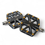 Dual-sided carbon fiber bike pedals with titanium spindle and gold removable spikes